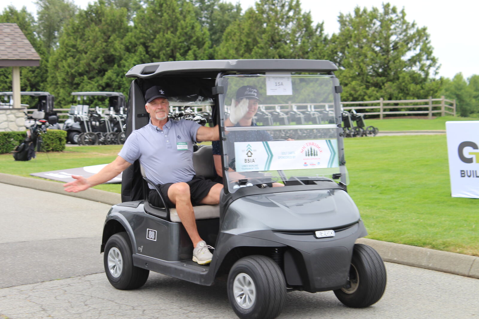 Golfers heading out from the clubhouse in their tournament cart