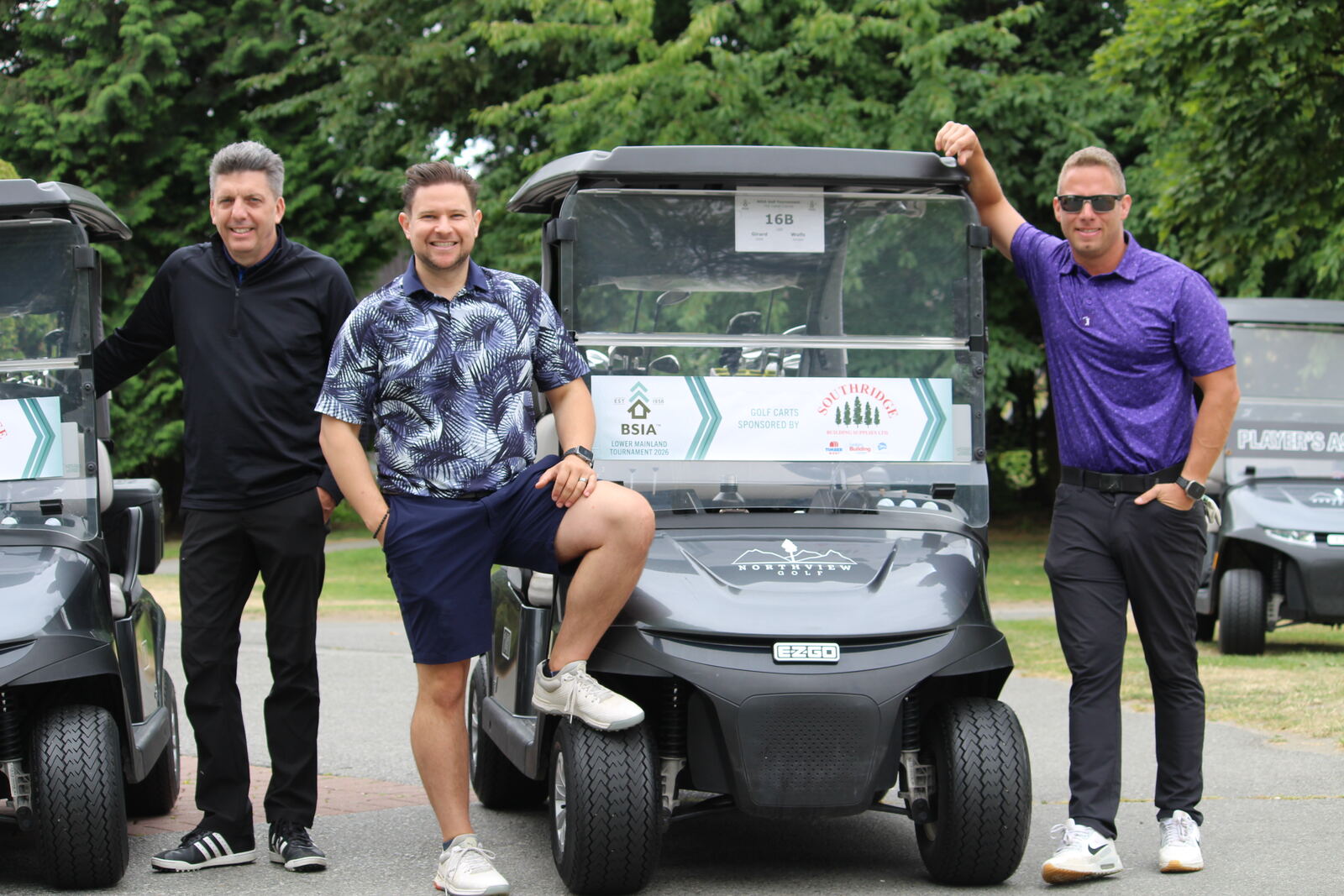 Three golfers posing with their tournament cart